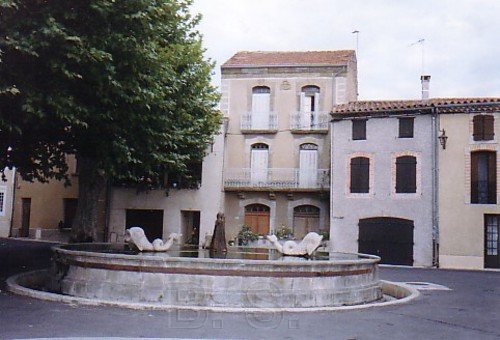 Le bassin sur la place du village et au fond la maison natale de Brenger Saunire (la plus haute au centre)